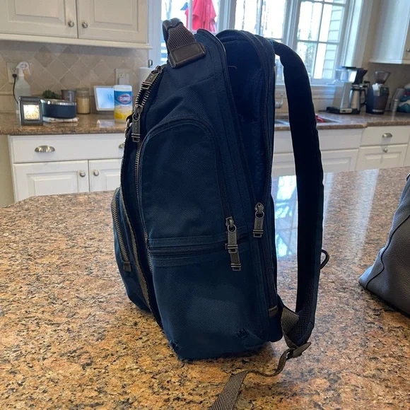 Tumi blue and black backpack. All zips & interior excellent. Two small spots.